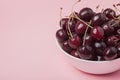 White bowl of fresh red cherries on a pink background. Copy space. close-up Royalty Free Stock Photo