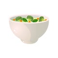 White bowl of green broccoli soup with fresh carrot