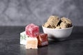 White bowl of halva and a pile of Turkish delight isolated on gray background