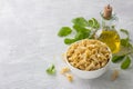 White bowl with italian dry pasta campanelle or bluebells from durum wheat with olive oil and young arugula leaves on light gray Royalty Free Stock Photo