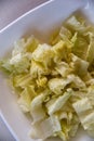 White bowl with lettuce leaves freshly cut for salad