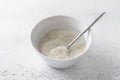 White bowl with long grain rice soaked in water on a light gray background. Cooking delicious steamed rice Royalty Free Stock Photo