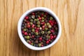 White bowl with pepper mix. Various pepper served in white bowl on wooden background. Royalty Free Stock Photo