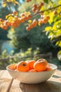 a white bowl of persimmons on a nature background