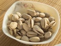 White bowl of pistachio nuts on a bamboo napkin Royalty Free Stock Photo