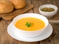 white bowl of pumpkin soup, garnished with parsley on wooden background, side view. Royalty Free Stock Photo