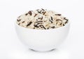 White bowl of raw organic basmati long grain and wild rice on white background. Healthy food Royalty Free Stock Photo