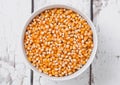 White bowl with raw sweet corn and popcorn on wood Royalty Free Stock Photo