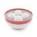 A white bowl with red designs holds four white balls Royalty Free Stock Photo