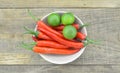 White bowl with red hot chili peppers and lemon on wooden background Royalty Free Stock Photo