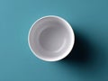 White bowl is sitting on a blue surface Royalty Free Stock Photo