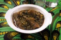 A white bowl of tasty Nigerian vegetable soup cooked with assorted meat,