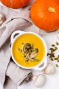 White Bowl of Tasty Pumpkin and Mushrooms Soup with Cream and Pumpkin Seeds on Linen Napkin White Wooden Background Top View Royalty Free Stock Photo