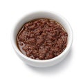 White bowl with traditional homemade black olive tapenade on white background