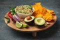 White bowl of traditional Mexican guacamole with nachos on grey concrete background. Tortilla chips with guacamole sauce dip and Royalty Free Stock Photo