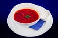 White bowl of traditional Ukrainian and Russian soup borsch or vegetable beetroot soup with sour cream on blue background Royalty Free Stock Photo