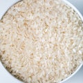White bowl of white rice on white background, top view, copy space. Close-up. Royalty Free Stock Photo