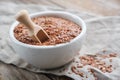 White bowl of whole flax seeds, linseeds on table. Royalty Free Stock Photo