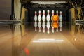 White bowling pins and an orange ball on a bowling alley. reflection Royalty Free Stock Photo