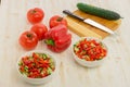 White bowls with fresh salad of green cucumbers, red tomatoes and bell peppers on light wooden surface. Vegetables. Lowcalorie Royalty Free Stock Photo