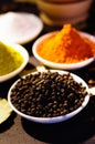 White bowls spread out with different colorful spices inside, beautiful rustic setting, spice and herbal concept Royalty Free Stock Photo
