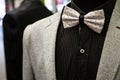 White bowtie with black dots, on display with a black shirt and a white wool suit jacket. Bow ties are a symbol of elegance and st Royalty Free Stock Photo