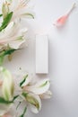 a white box of moisturizer, perfume or lipstick and a bouquet of white alstroemeria