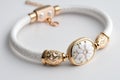white bracelet with delicate gold details and charm