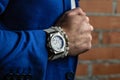 White bracelets and watches made of natural stones and minerals on a manÃ¢â¬â¢s hand. Accessories and jewelry on a brick wall