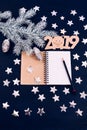 Blue background stars christmas tree branch white bump notebook letters symbols 2019 decoration top view greeting card