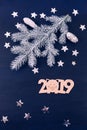 Blue background stars christmas tree branch white bump notebook letters symbols 2019 decoration top view greeting card