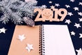 Blue background stars christmas tree branch white bump notebook letters symbols 2019 decoration top view greeting card