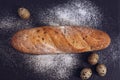 White bread was sprinkled with flour and quail eggs on a gray stone plate. Royalty Free Stock Photo