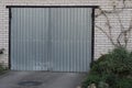 White brick garage with a gray closed metal gate Royalty Free Stock Photo
