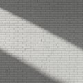White brick wall with a diagonal shadow cast across it, creating a contrast between li Royalty Free Stock Photo