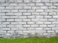 White brick wall on green grass floor, grung vintage wallpaper and background