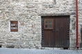 White brick wall with old wooden front door, window and red rainwater downpipe Royalty Free Stock Photo