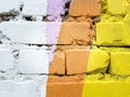 White brick wall painted with purple orange and yellow paint Royalty Free Stock Photo