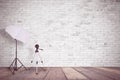 White brick wall in a photo studio. An umbrella for illumination and a tripod for a camera. Empty copy space