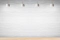 White brick wall in room with wooden floor with lamps. Royalty Free Stock Photo