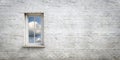 White brick wall with single pane window reflecting clouds. Generative AI Royalty Free Stock Photo