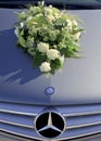 White bridal bouquet upon Mercedes car