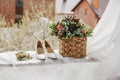 white bridal shoes and flowers in the basket Royalty Free Stock Photo