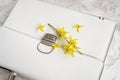 White briefcase and yellow flowers close-up top view, selective focus. Concept of sesonal shopping, business and romance