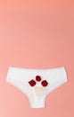 White briefs with menstrual cup and rose petals. Royalty Free Stock Photo