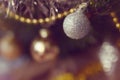 White brightening christmas ball close-up with yellow gerland on a branch in the Christmas and New Year holiday