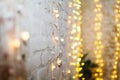 White brike wall with blurred background with bokeh lights, electric garland. Royalty Free Stock Photo