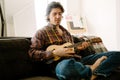 White bristle man playing ukulele while resting on couch Royalty Free Stock Photo