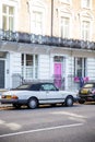 White British houses with classic cars parked outside