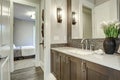 White and brown bathroom boasts a nook filled with taupe vanity